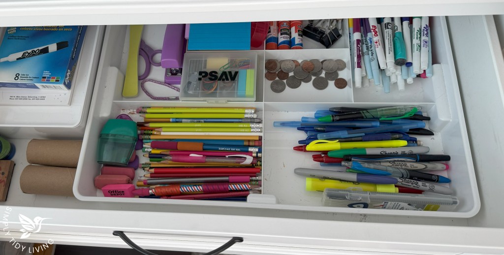 The same drawer as in the Before picture, this time, organized with pencils, pens, markers, coins, note pads, and office supplies all neatly organized.